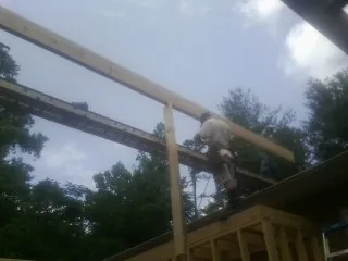 Carpenter setting a ridge beam over a new addition frame — Ice Dam Removal by Roofing Brothers in Gardiner