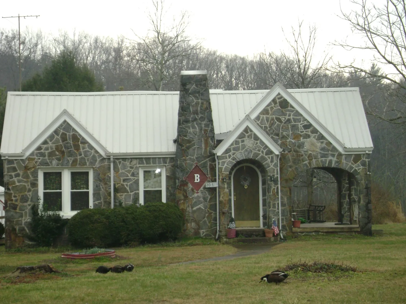 White metal roof on a stone cottage with steep gables in Gardiner