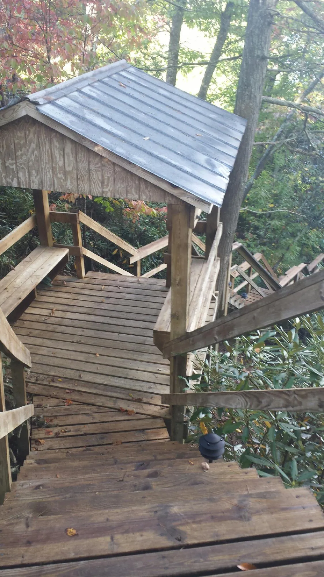 Metal roofed shelter over wooden steps on a wooded walkway — Skylight Repair & Installation work by our crew in Gardiner